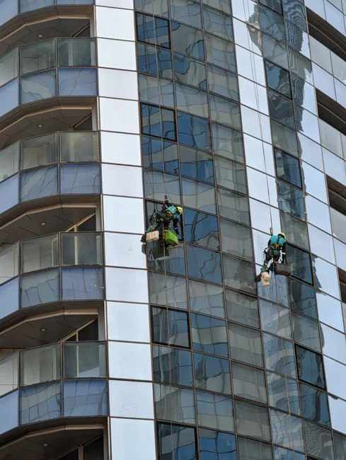 Close-up of a professional in full protective gear disinfecting a surface indoors.